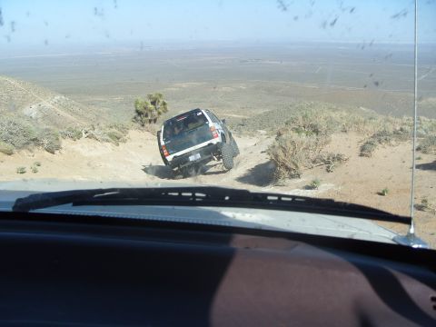 1995 Ford Bronco - SUV tackles a challenging off-road path in a dry, arid environment.
