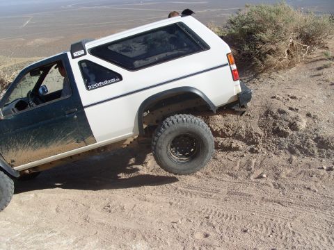 1995 Ford Bronco - SUV with off-road tires navigating a steep dirt incline.