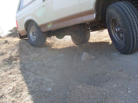 1995 Ford Bronco - This Ford Bronco is navigating a steep, rocky incline on a dirt path.