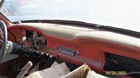 1972 Ford Ranchero - The interior of a vintage vehicle shows a red dashboard with a tan top surface. Visible components include a steering wheel, column shifter…