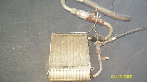 1972 Ford Ranchero - A car's air conditioning evaporator core and associated hoses are laid out on a dark, textured surface. The evaporator core is rectangular…