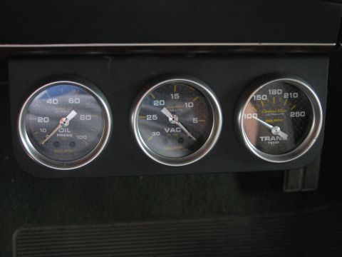 1990 Ford F-150 - Close-up of aftermarket gauges mounted on a dashboard, showing oil pressure, vacuum, and transmission temperature readings.