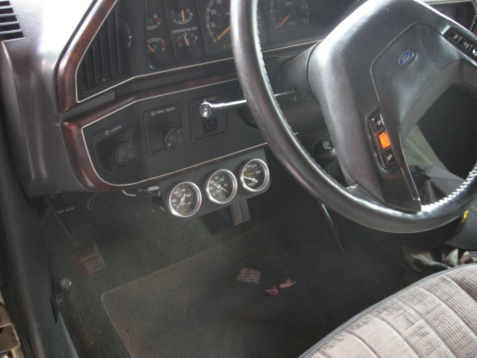 1990 Ford F-150 interior with three gauges below the dashboard
