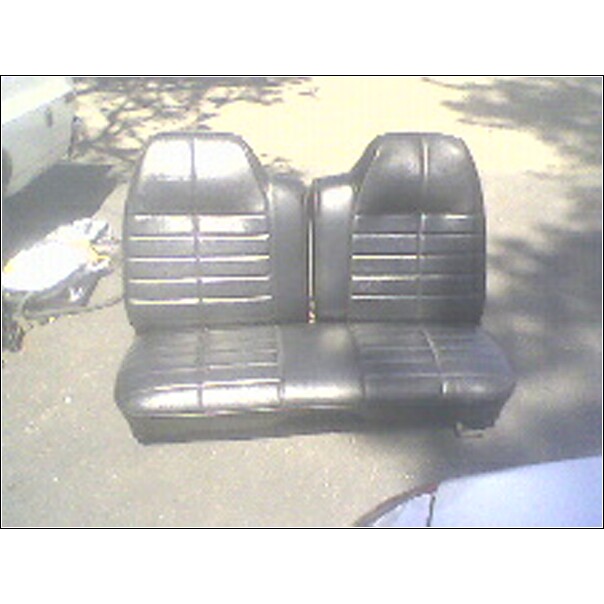 Black vinyl split bench seat sitting outdoors on pavement