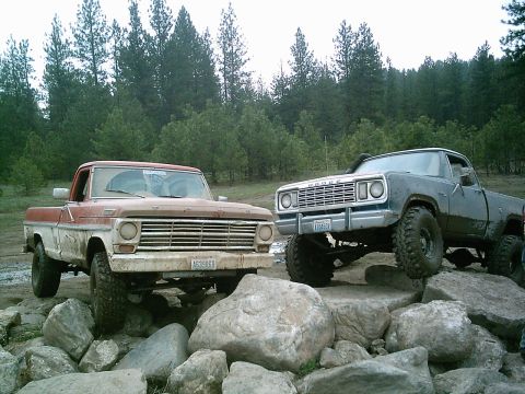 1968 Ford F-250 - A blue Dodge pickup truck navigates rocky terrain, its off-road capabilities.