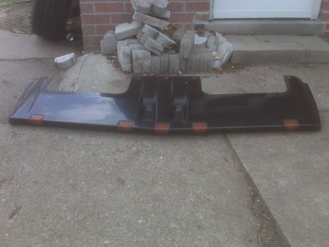 1995 Ford Bronco - A dark truck visor with amber marker lights is shown lying on a concrete surface.