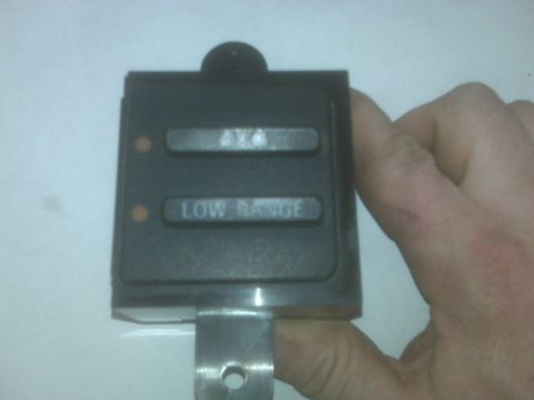 1995 Ford Bronco - This switch panel for 4x4 and Low Range operation is held by a hand.