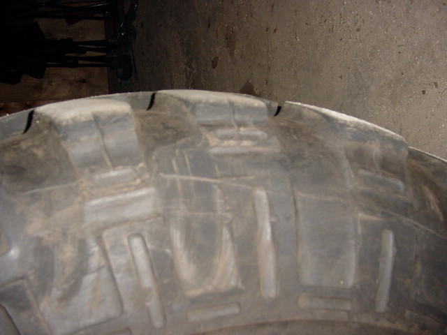 Close-up of a tire tread with the Supermotors.net logo in the corner