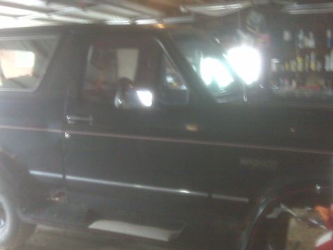 1995 Ford Bronco - Black 1995 Ford Bronco side profile, parked inside a garage with shelves in the background.