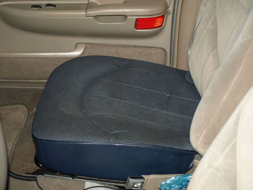 Interior view of a car seat and part of the ceiling with a taillight visible