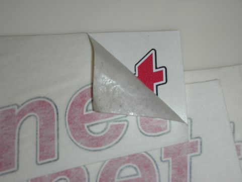 1998 Ford Crown Victoria - Photograph of vinyl lettering decals with the paper backing partially peeled on a white surface.