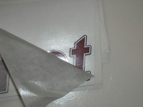 1998 Ford Crown Victoria - Photograph of a vinyl lettering decal with its paper backing partly removed on a white surface.