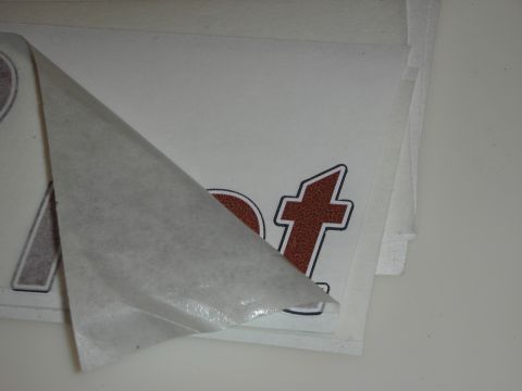 1998 Ford Crown Victoria - Photograph of stacked vinyl lettering decals with paper backing partially peeled.