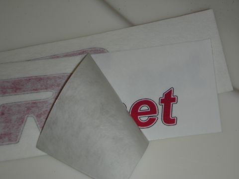 1998 Ford Crown Victoria - Photograph of vinyl lettering decals with red text and a partially peeled backing.