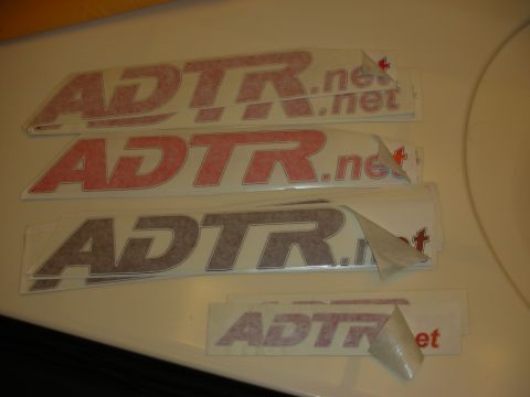 1998 Ford Crown Victoria - Photograph of multiple ADTR.net vinyl lettering decals in red and gray arranged on a light surface.