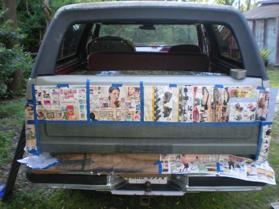 Ford Bronco tailgate masked with newspaper and blue tape for refinishing