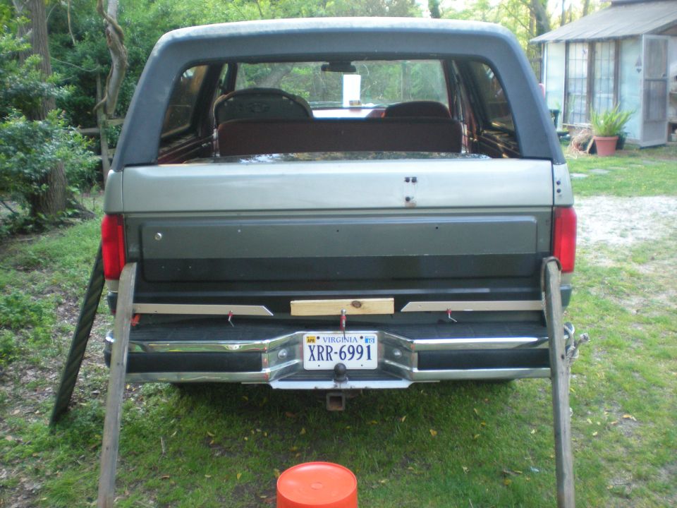 Rear view of a 1990 Ford Bronco with wooden planks attached to the bumper.