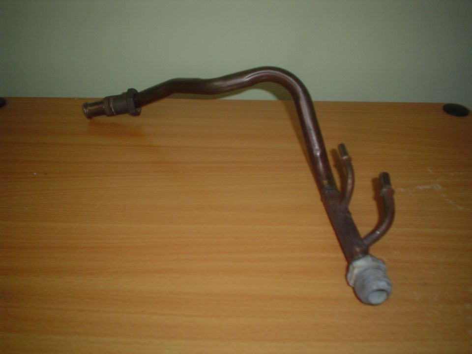 Bent copper pipe with fittings on a wooden table