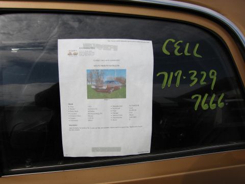 2001 Ford Crown Victoria - Photo of a printed for-sale listing flyer in a car window with a handwritten phone number, not a clean piece of literature.