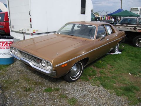 2001 Ford Crown Victoria - A brown 1970s Plymouth Barracuda is seen from a three-quarter front angle.