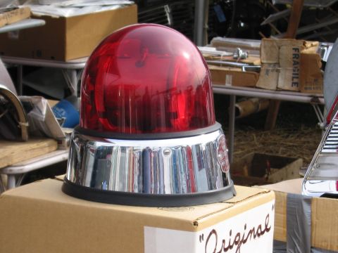 2001 Ford Crown Victoria - A red beacon light with a chrome base sits on a cardboard box, surrounded by other items.