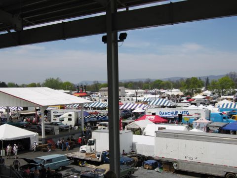 2001 Ford Crown Victoria - A busy outdoor event with numerous vehicles and vendor tents spread across the grounds.