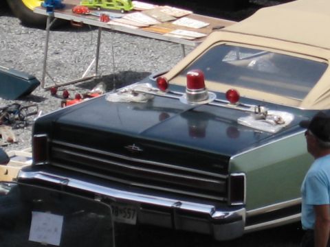 2001 Ford Crown Victoria - This sedan, equipped with emergency lights, appears to be from the late 1970s, not a 2001 model.
