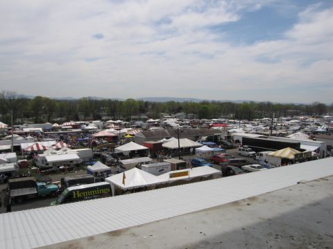 2001 Ford Crown Victoria - A busy outdoor market is depicted with many tents and vehicles under a cloudy sky.