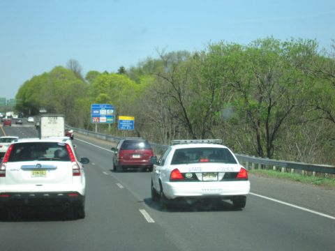 2001 Ford Crown Victoria - Photo of a State Police cruiser in highway traffic, not a technical document.