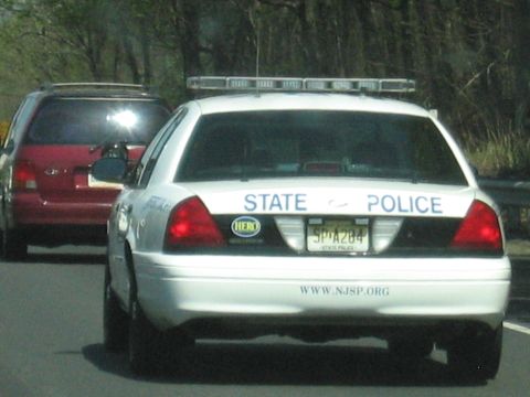 2001 Ford Crown Victoria - Photo of the rear of a NJ State Police cruiser on the highway, not a technical document.