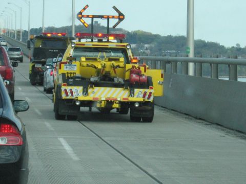 2001 Ford Crown Victoria - Photo of a yellow tow truck driving across a bridge, not a technical document.