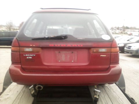 1998 Subaru Legacy - Rear view of a red 1998 Subaru Legacy wagon, showing the SUBARU and LEGACY badging.