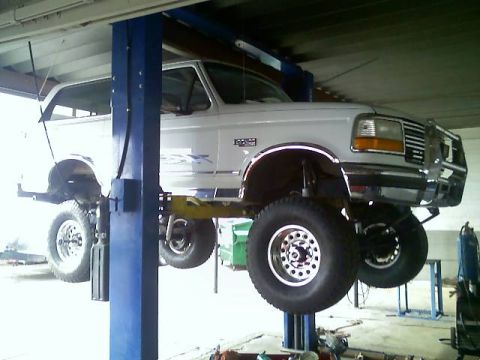 1996 Ford Bronco - White 1996 Ford Bronco lifted for service in a garage.