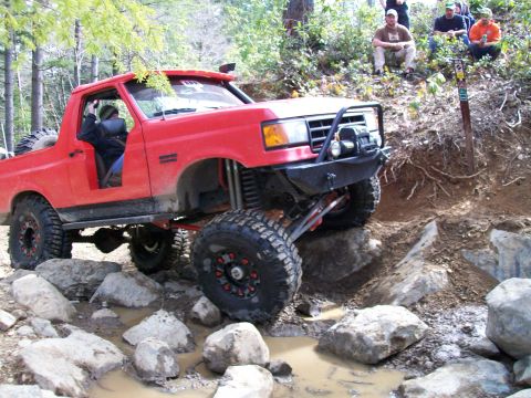 1989 Ford Bronco - This modified red Bronco navigates a challenging rocky obstacle course.