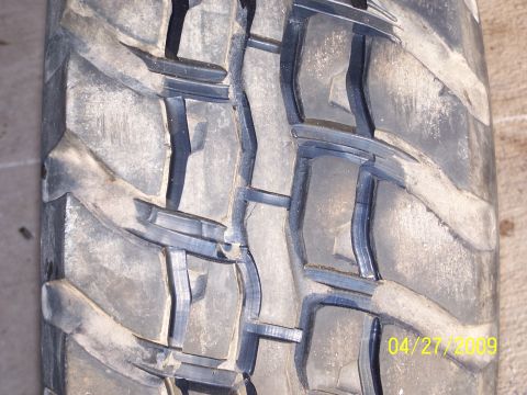 1989 Ford F-150 - A close-up view of a tire tread shows its aggressive pattern and signs of wear.