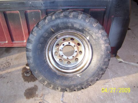 1989 Ford F-150 - A tire and wheel assembly is shown next to the side of a truck bed.