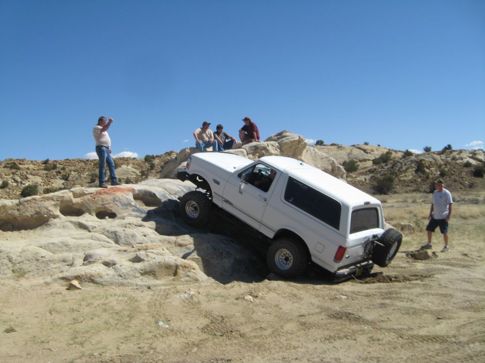 White 1993 Ford Bronco climbing rocky terrain