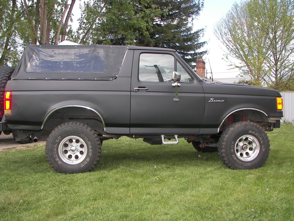1987 Ford Bronco with a soft top, parked on grass