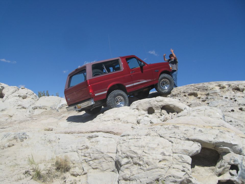Red 1993 Ford Bronco climbing rocks
