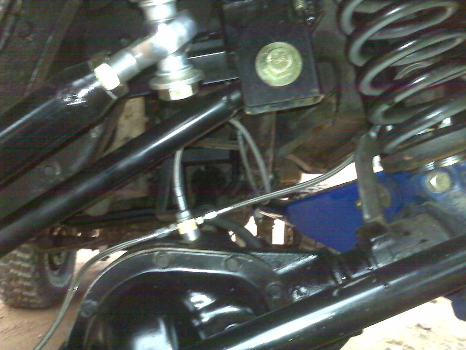 Close-up of a vehicle's rear differential and suspension with black tubing and a silver joint