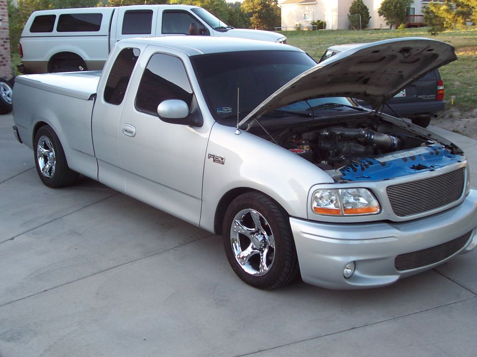 Silver 1998 Ford F-150 with hood open, showing engine and custom wheels