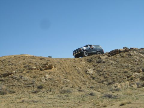 1993 Ford Bronco - This SUV is navigating a steep, off-road trail on a sunny day.