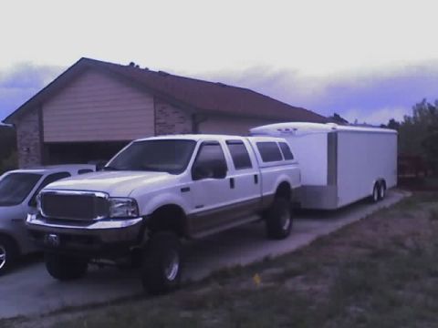 2000 Ford F-250 - White 2000 Ford F-250 Super Duty truck is parked and towing a large enclosed trailer.