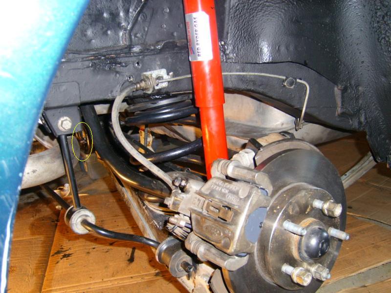 Vehicle rear suspension with red shock, coil spring, brake disc and caliper