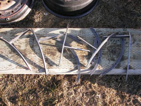 1990 Chevrolet Suburban - Metal trim pieces are arranged on a wooden plank, with two tires visible behind them.