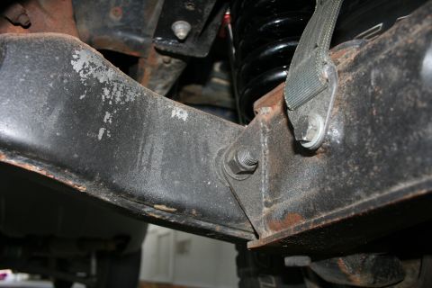 1984 Ford Bronco - Detail of the front suspension system, showing a rusty bracket and coil spring, with a Supermotors.net watermark.