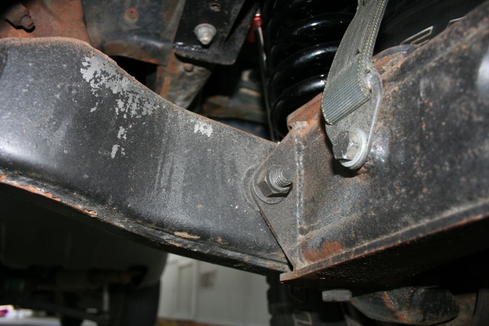 Close-up of rusty front suspension bracket and coil spring