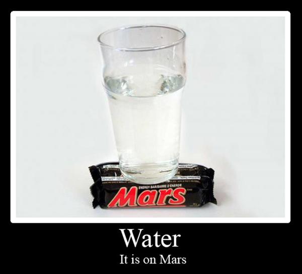 glass of water sitting on top of two Mars bars