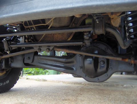 1995 Ford Bronco - The photo shows the undercarriage of a vehicle, focusing on the front axle and steering system.