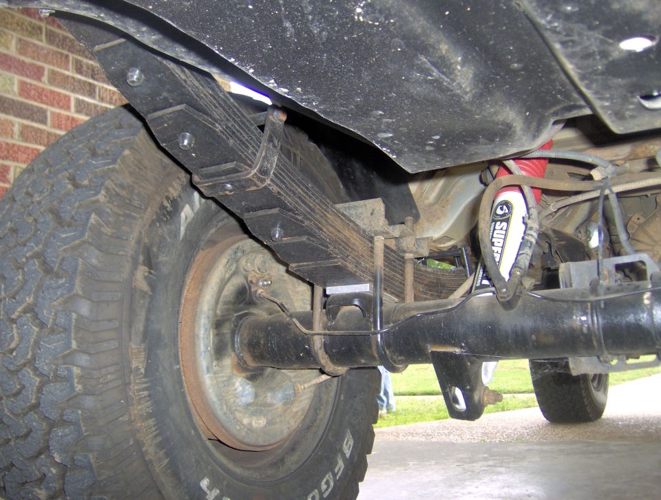Rear axle assembly with leaf springs and red shock absorber. BFGoodrich tire visible